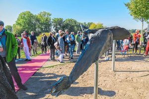 Wie kommt die Keramik an den Schiefer? Zwei Experten fachsimpeln an Anne Husters Fisch-Skulptur auf dem Emsdeich. Foto: Günter Benning