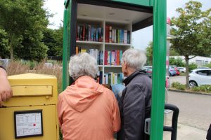 Foto Telefonzelle mit Büchern und ersten Nutzern