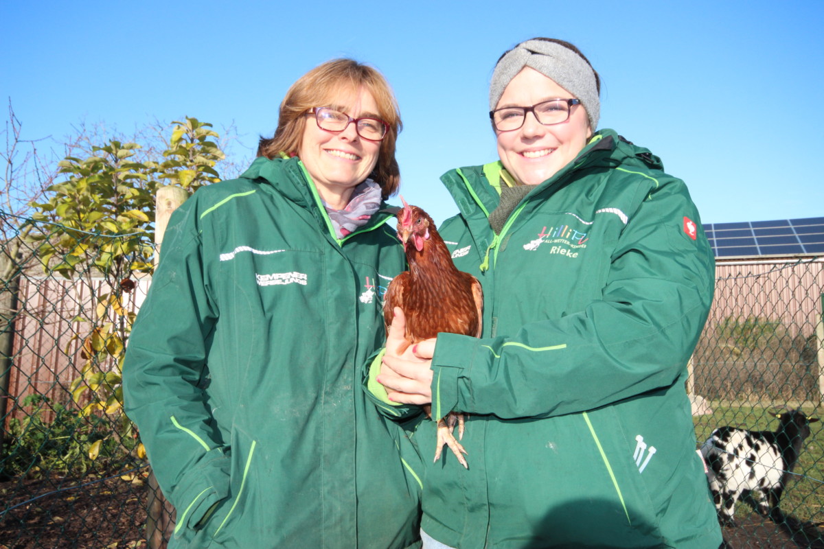 Foto: Zwei Frauen mit Huhn auf dem Arm