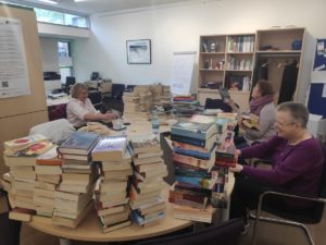 Foto von gestapelten Büchern auf dem Tisch im Quartiersbüro