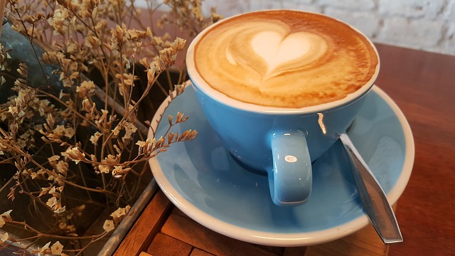 Blaue Tasse mit Kaffee auf einem Holztisch
