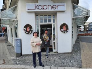 Stefanie Kapner von Betten Kapner in Herten nimmt Blumenstrauße als Siegerin der Oster-Aktion entgegen – sie hat das schönste Frühlings-Schaufenster in Herten-Mitte